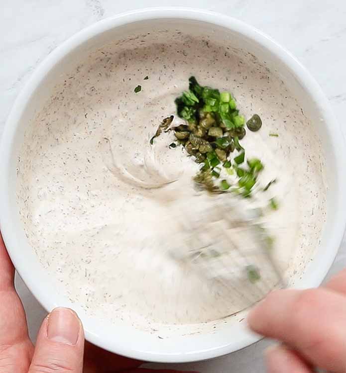 Whisking in the chiles, capers, and cilantro.