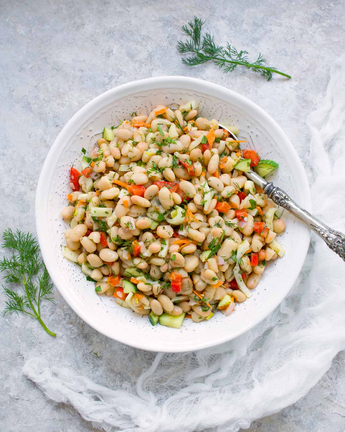 Herbed white bean picnic salad in a large white serving bowl