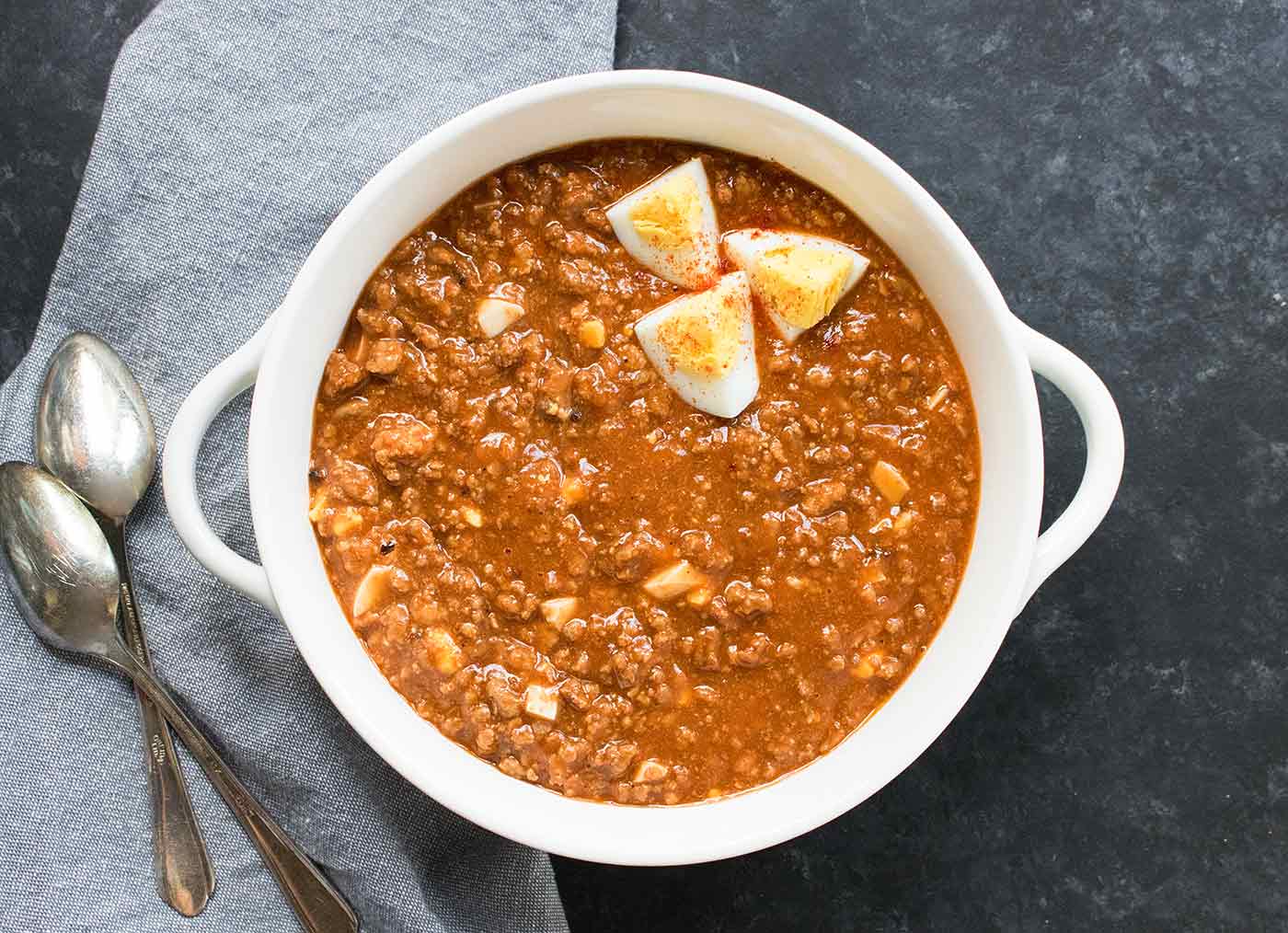 Mock Turtle Soup in a white bowl, topped with hard boiled eggs