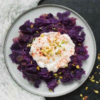 A plate of Instant Pot Okinawan Sweet Potatoes topped with coconut milk and feta cream