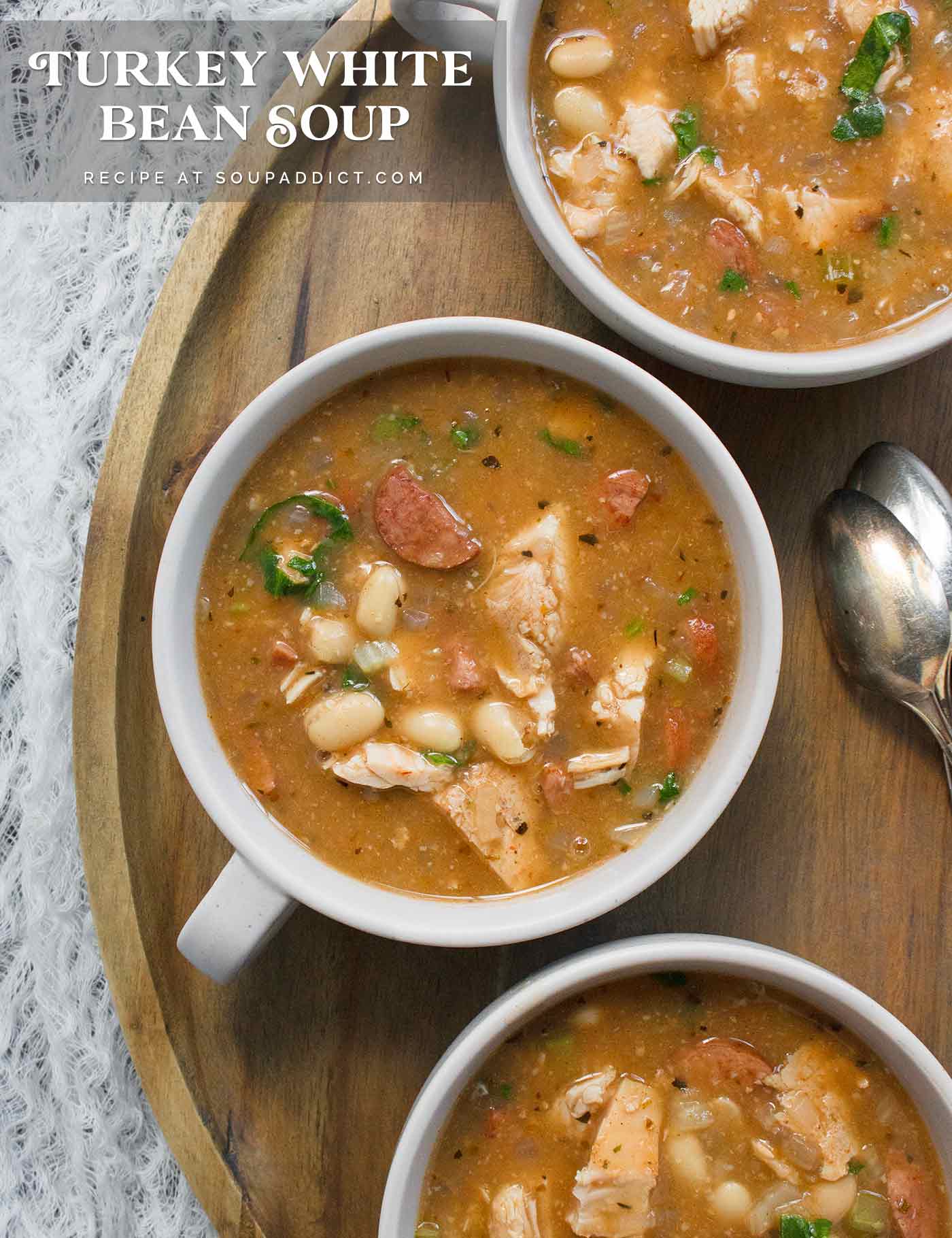 Three bowls of Turkey White Bean Soup on a wooden serving tray