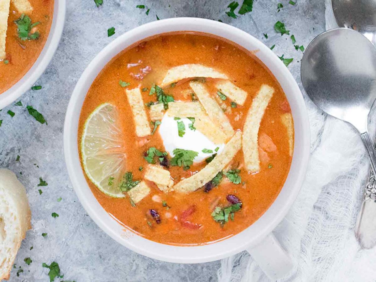 Instant Pot Chicken Tortilla Soup with topings in a gray soup bowl.