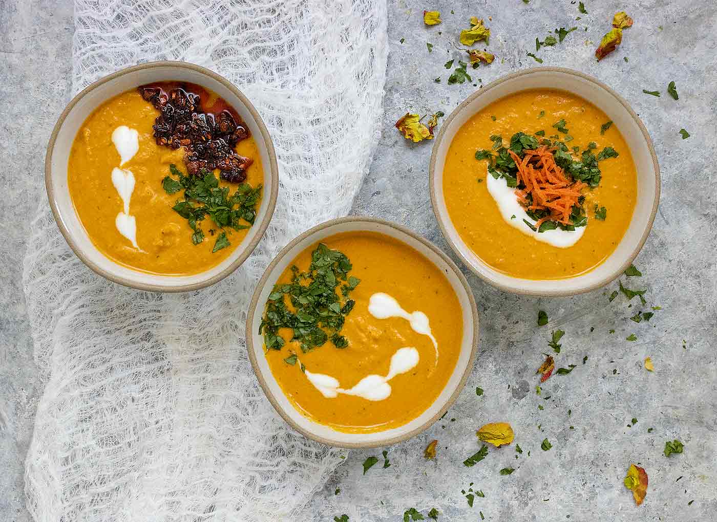 Three bowls of carrot gazpacho.