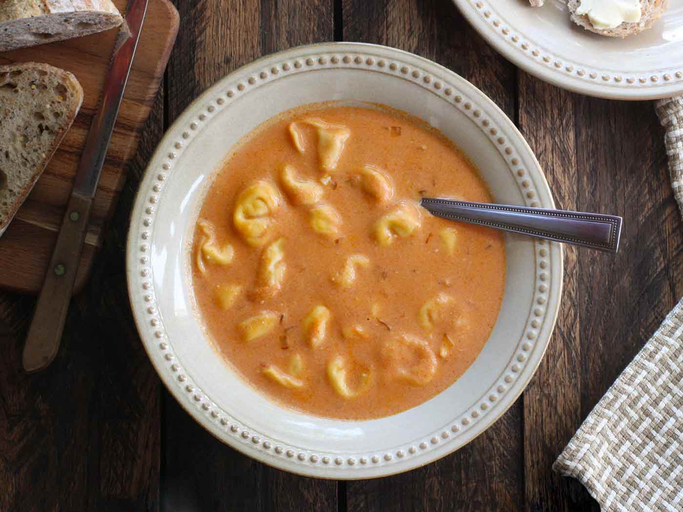 Overhead view of a bowl of Creamy Tomato Tortellini Soup.