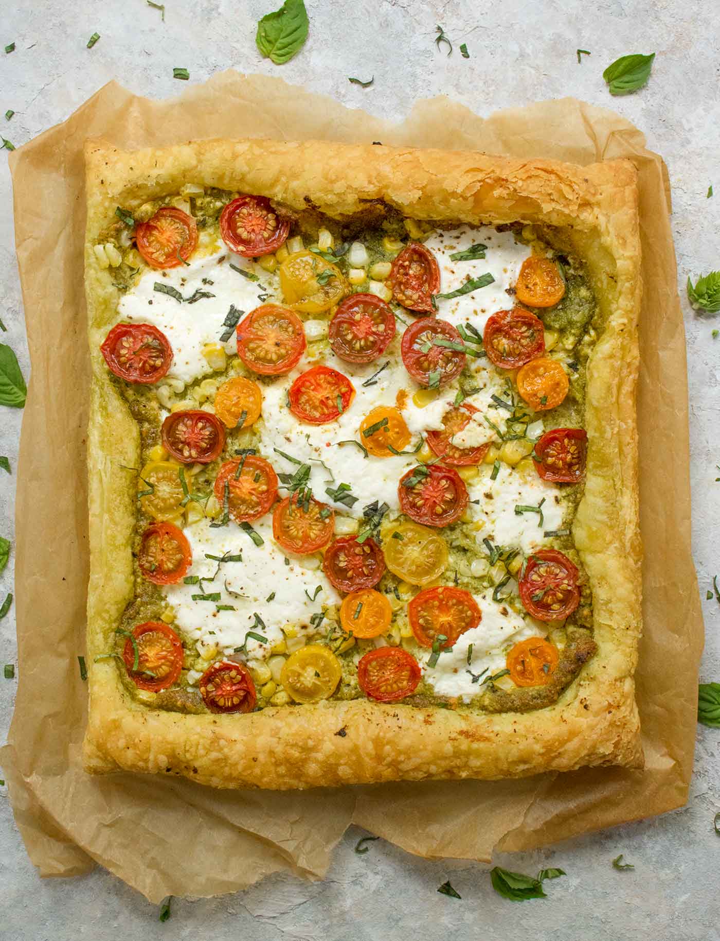 Puff pastry cherry tomato tart on parchment paper