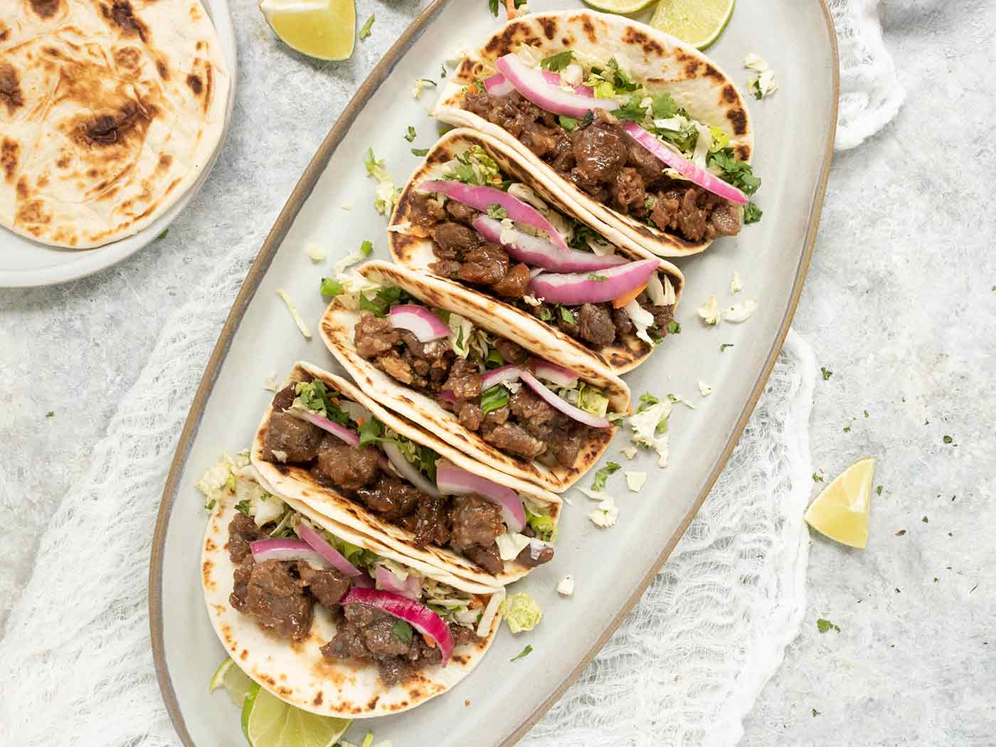 Five Korean BBQ Beef Tacos stacked side by side on a platter.