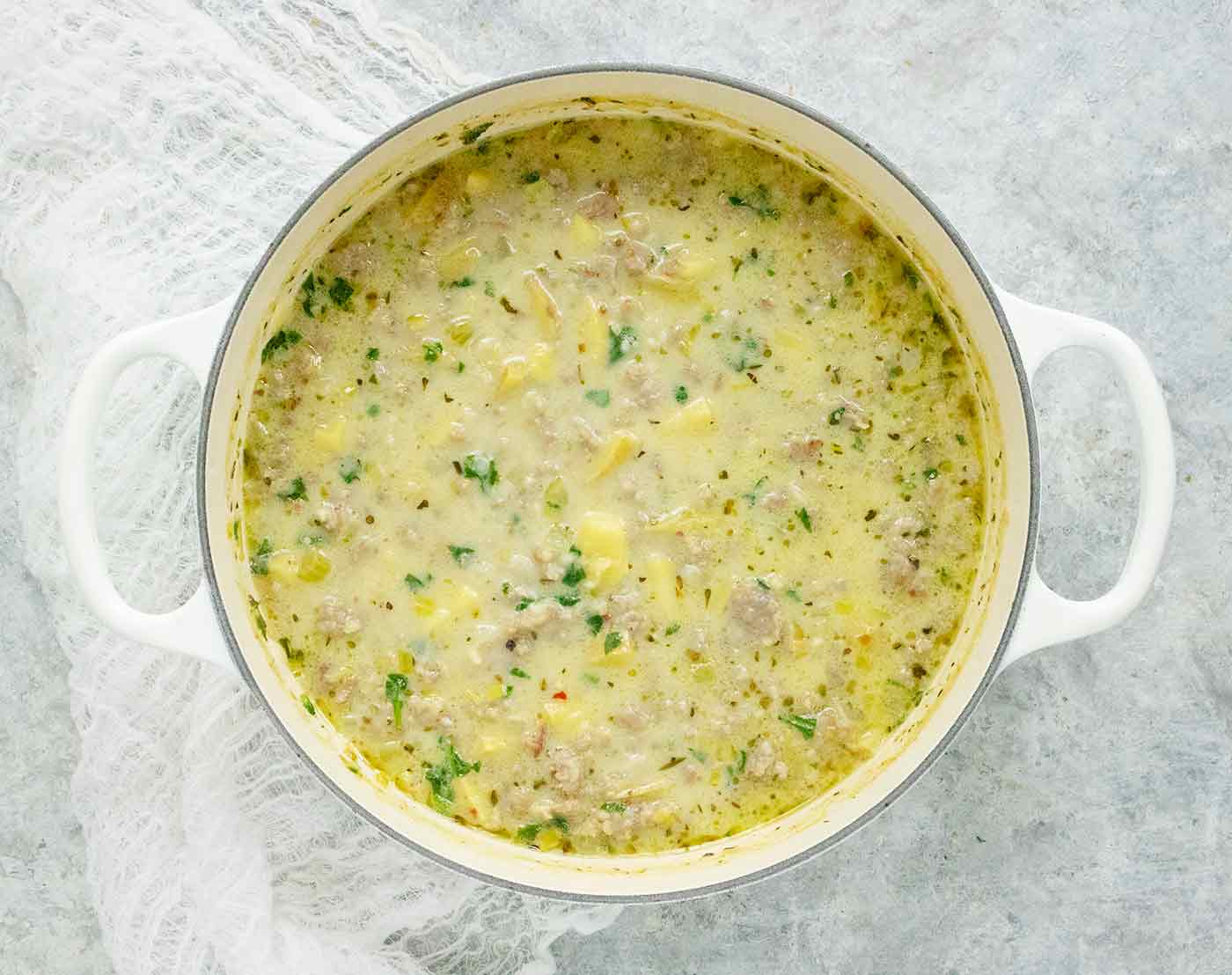 Tuscan Potato Soup in a white Dutch oven