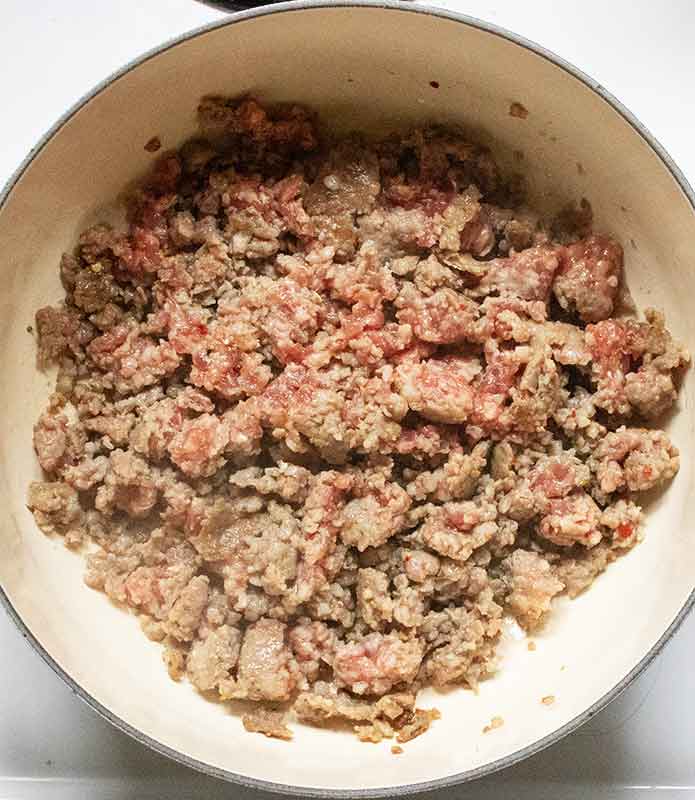 Cooking the ground sausage in the soup pot.