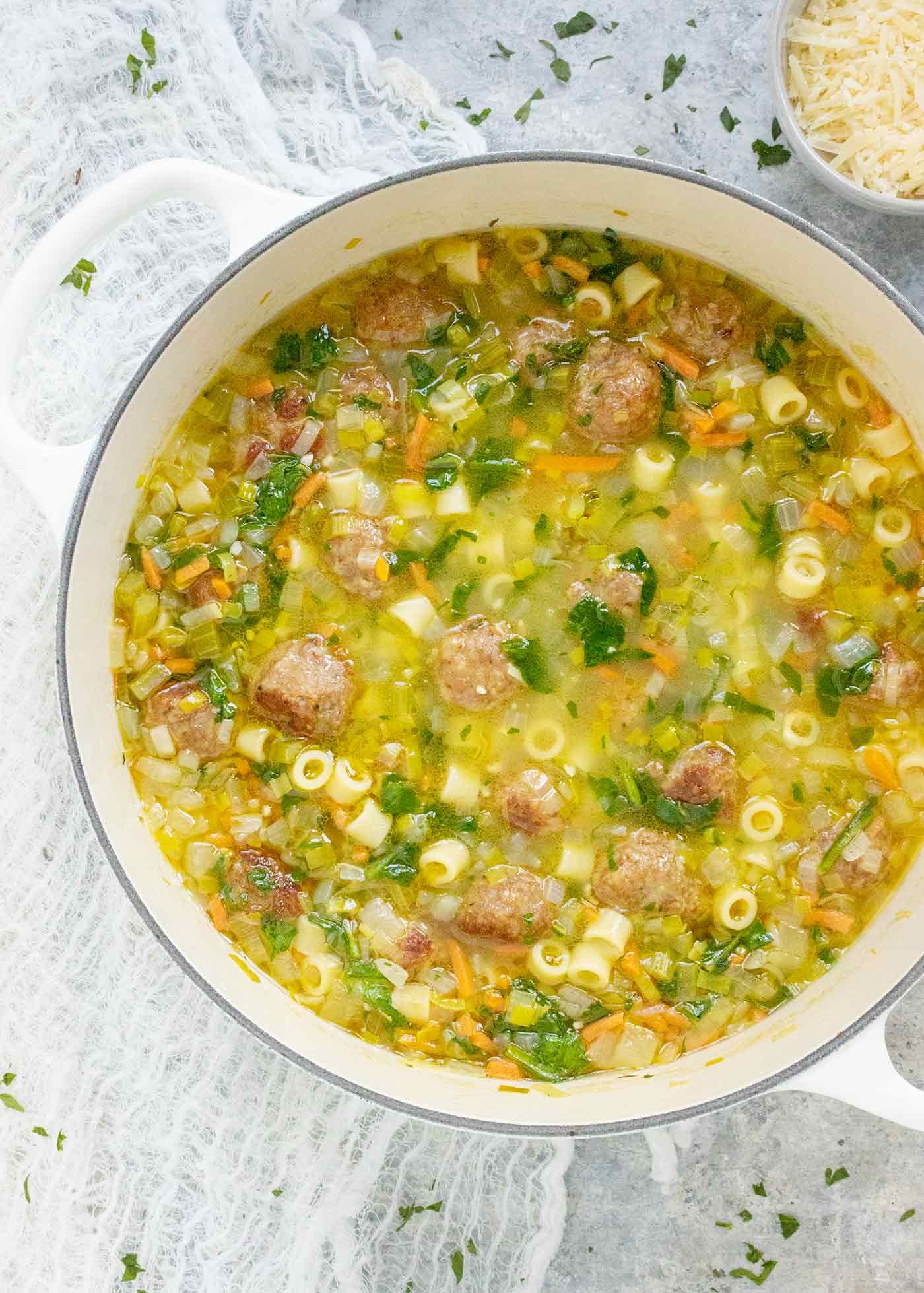 Italian Wedding Soup in a white Dutch Oven.