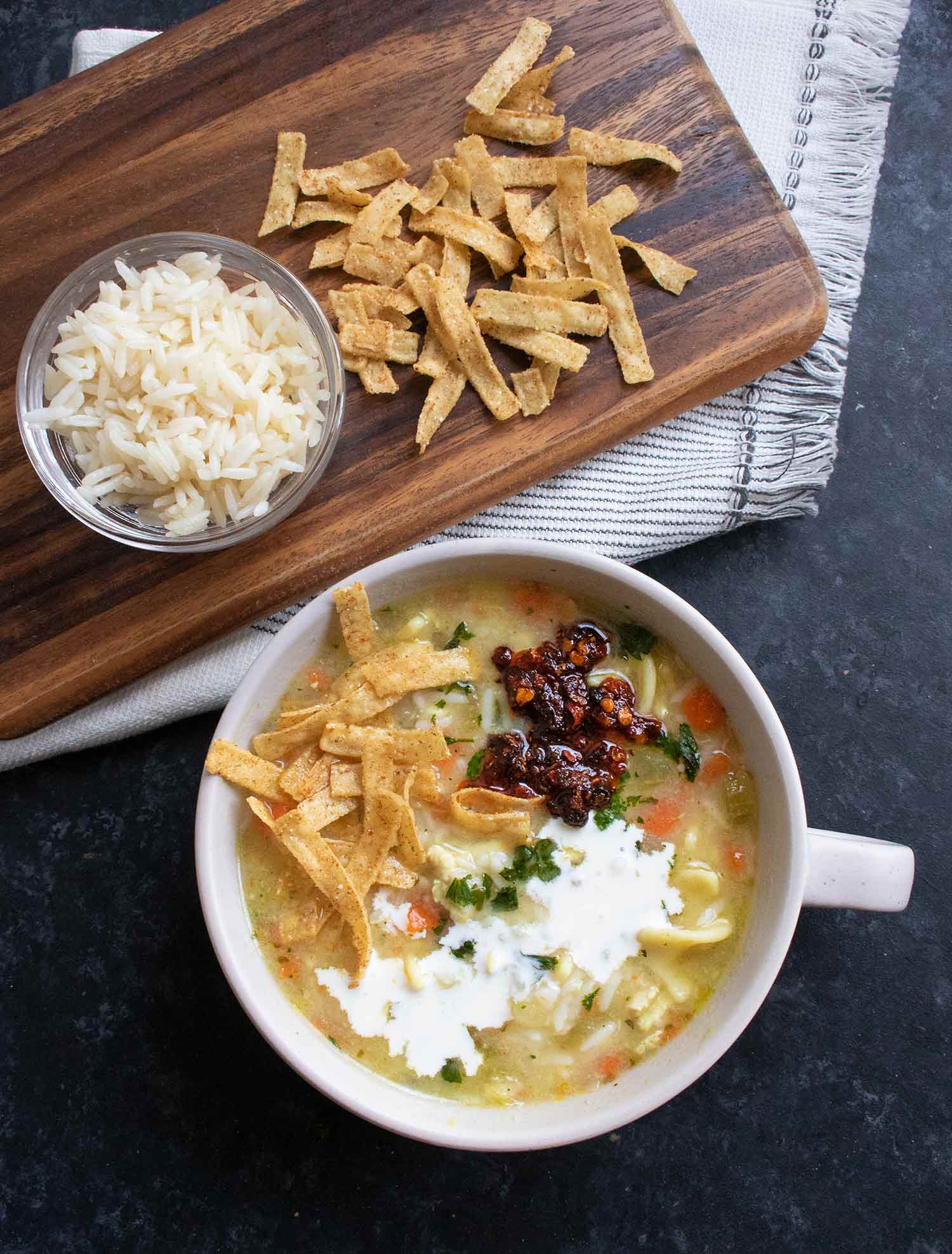 Leftover chicken noodle soup with toppings on the side.