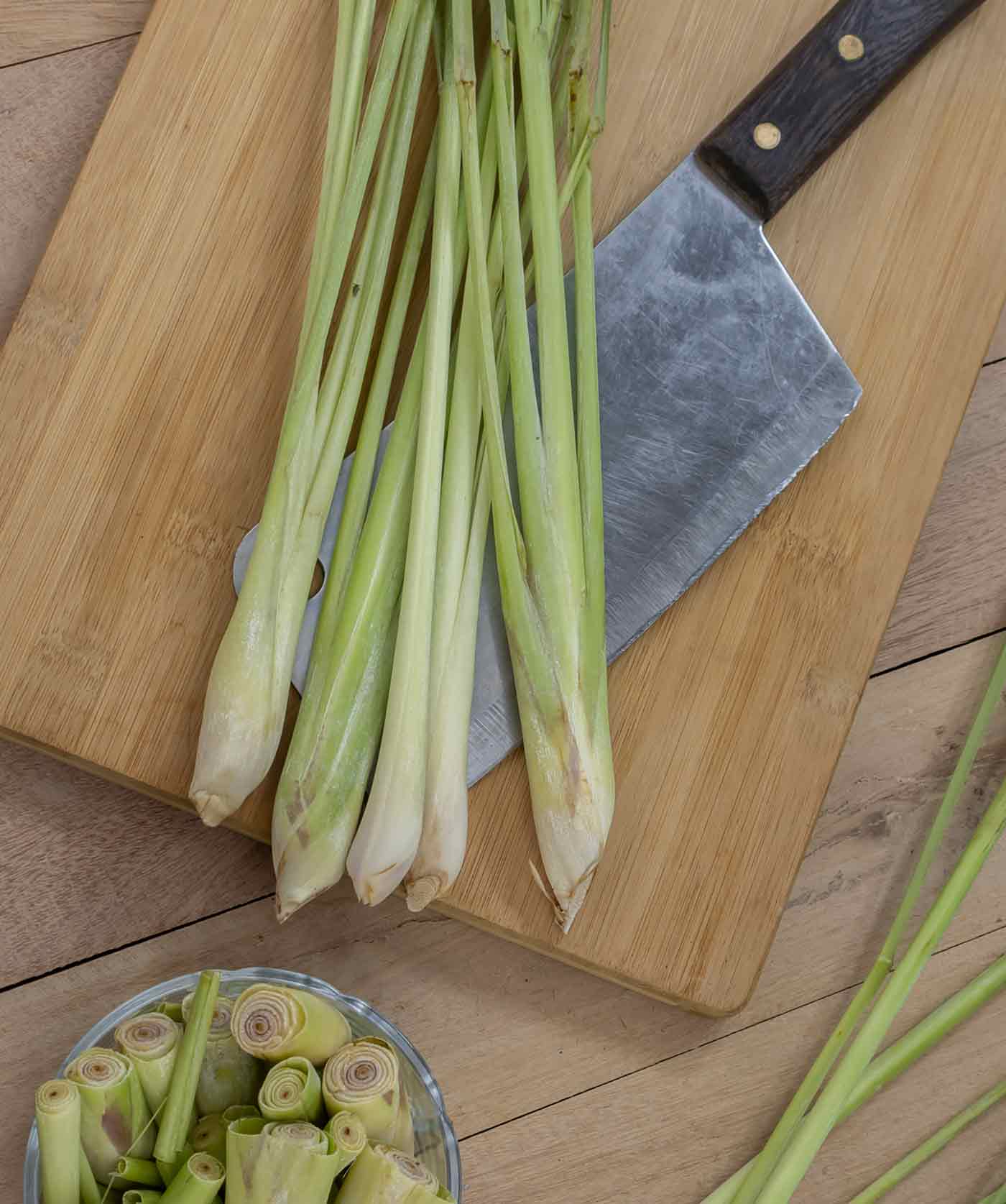 Lemongrass stalks on a cutting board with a chef's knife.