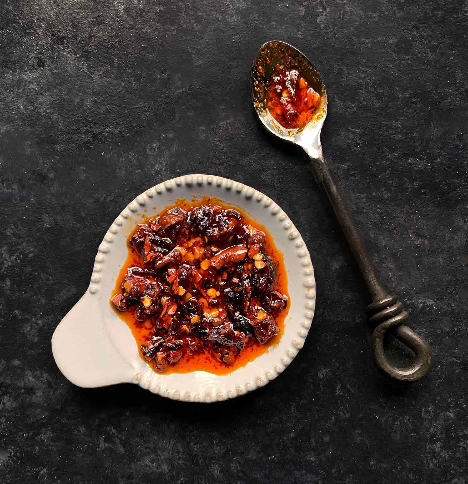 Chili crisp on a small plate with a spoon.