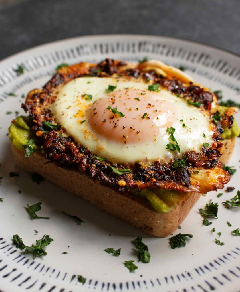 Side view of a Chili Crisp Fried Egg on avocado toast.