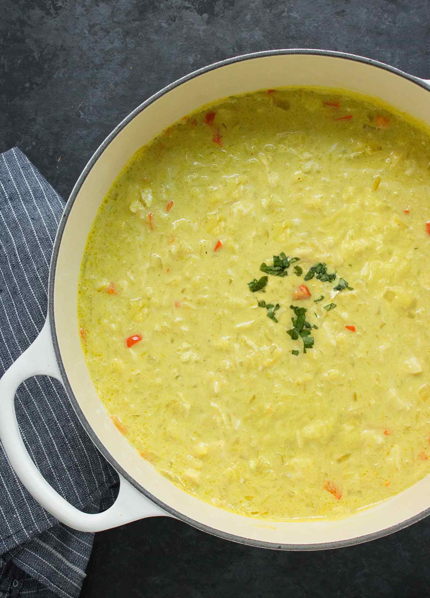 Overhead view of Thai Coconut Chicken Soup in a large white Dutch oven.