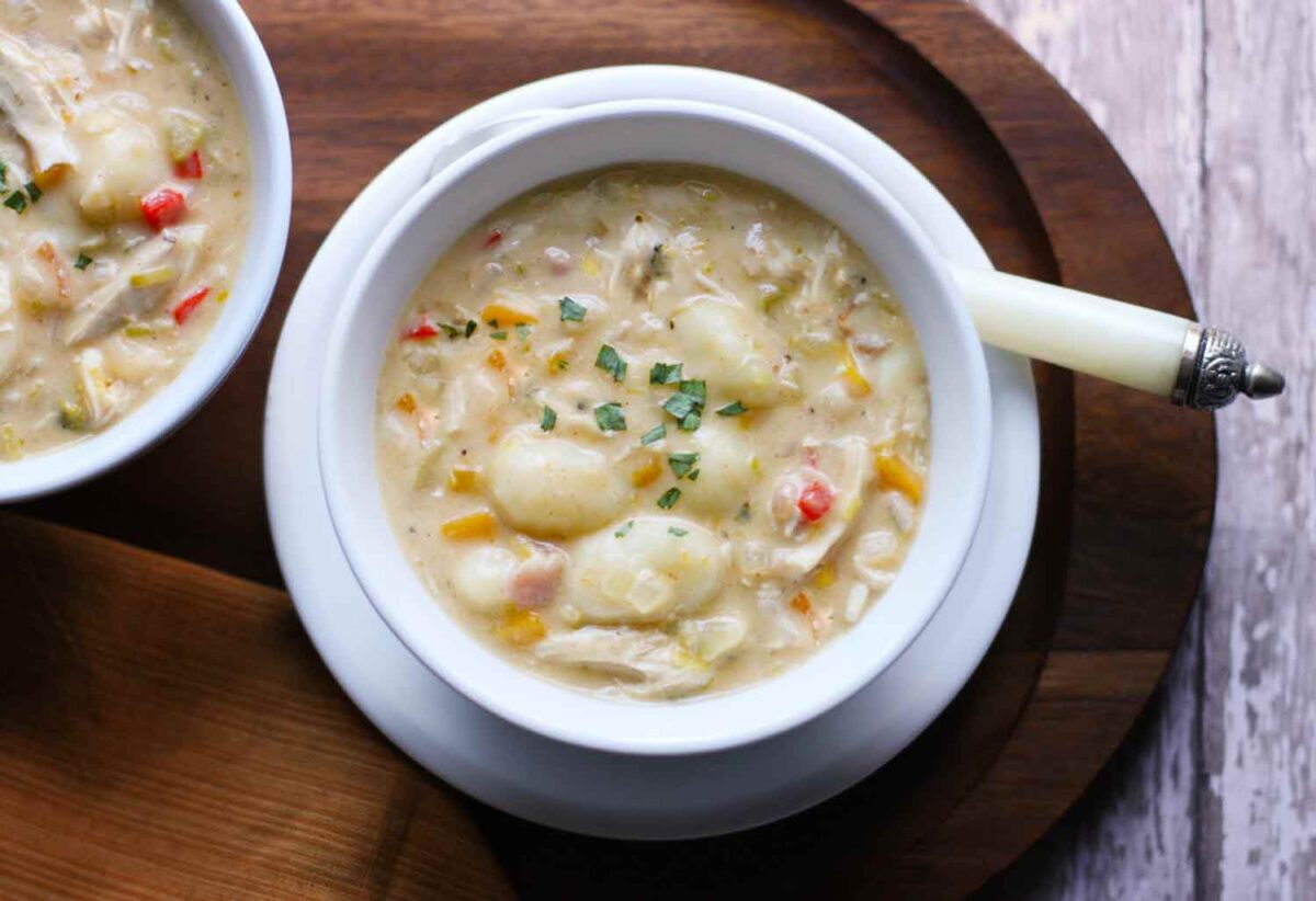 Chicken Gnocchi Soup in a white bowl with a spoon.