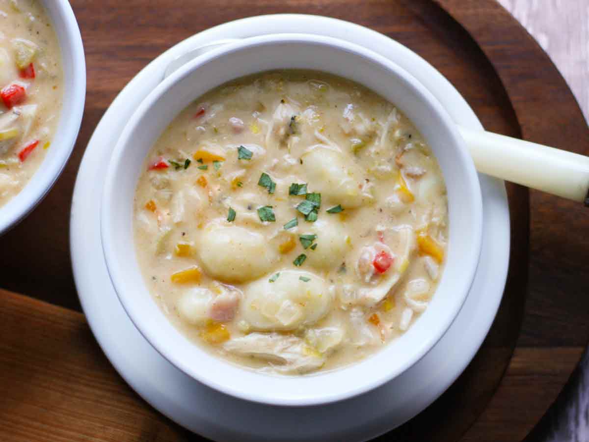 Chicken Gnocchi Soup in a white bowl with a spoon.