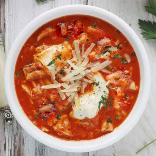 Overhead shot of Chicken Parmesan Soup in a white bowl.
