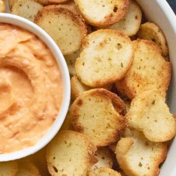 Close-up of homemade bagel chips with a bowl of hummus.