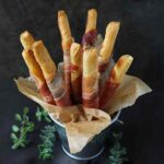 Prosciutto-wrapped Breadsticks in a serving tin.