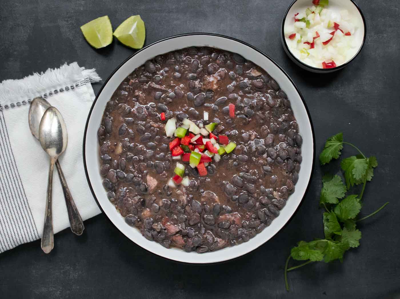 Overhead view of a bowl of Cuban Black Bean Soup in a white bowl with a black rim.