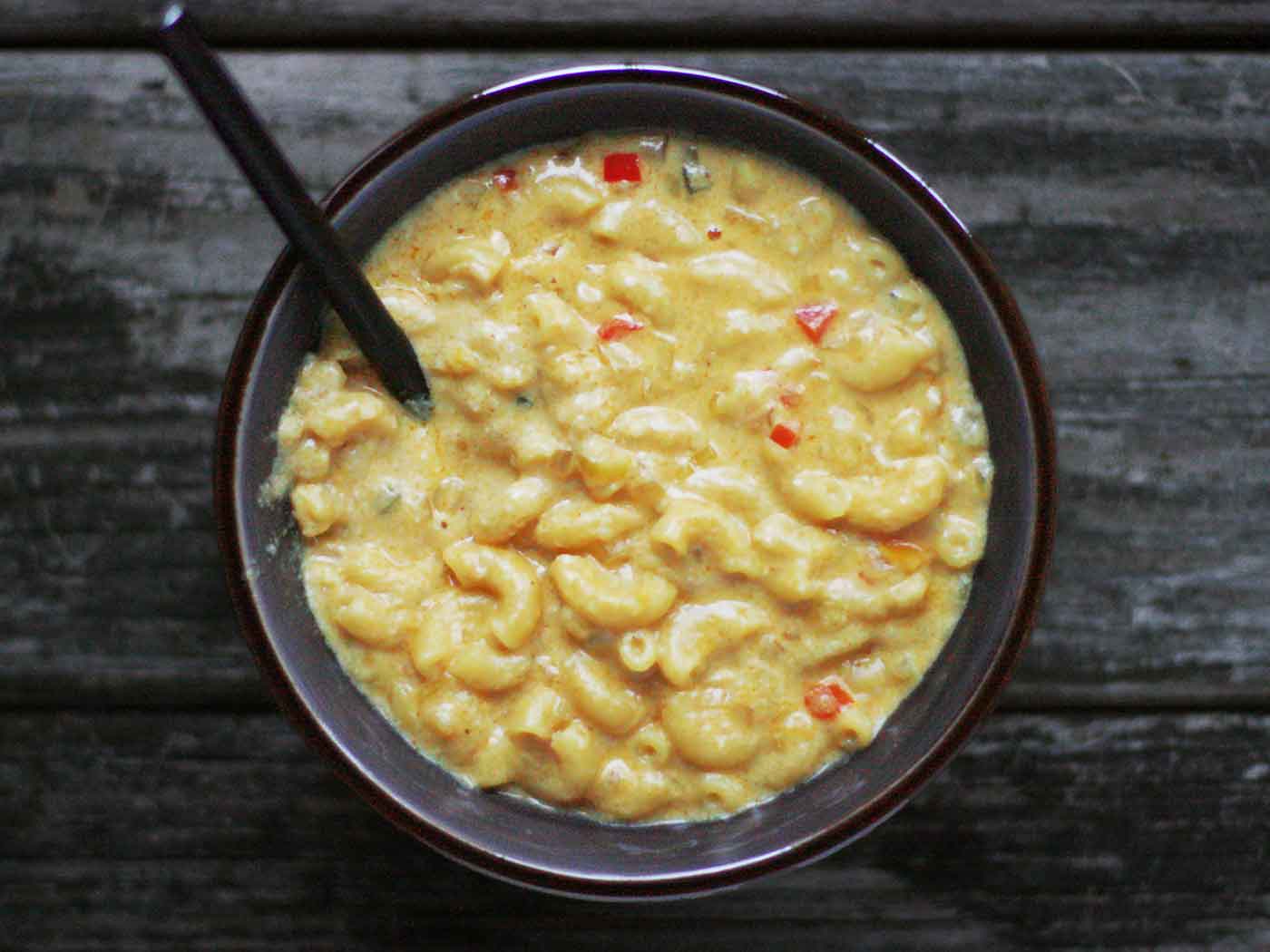 Overhead view of Mac and Cheese Beer Soup in a black bowl.