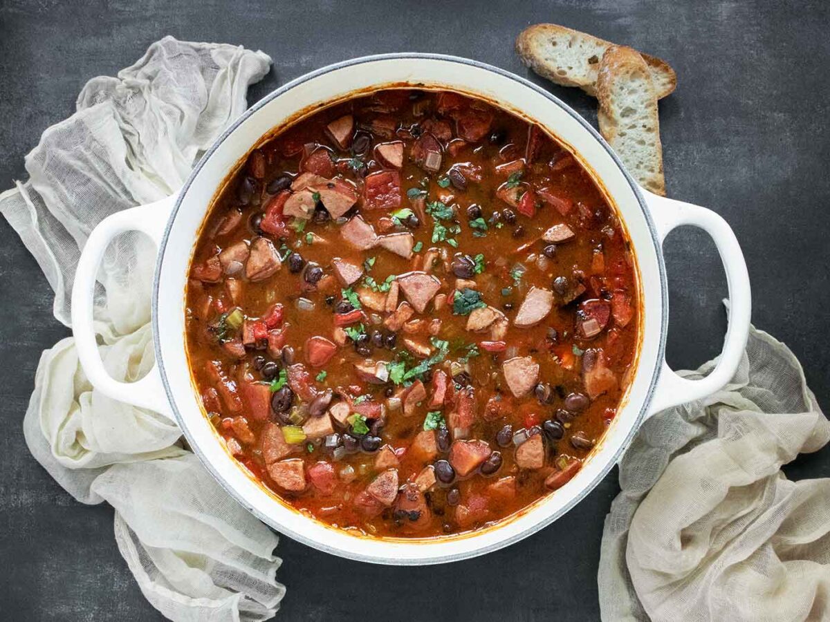 Smoky Black Bean and Sausage Soup in a large white Dutch oven.