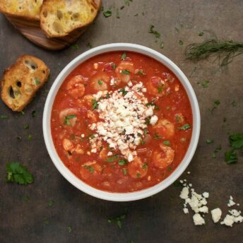 Overhead view of a bowl of Shrimp Saganaki Soup.