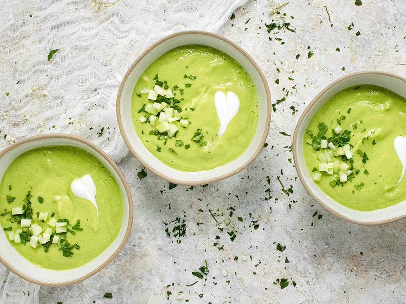 Overhead view of three bowls of Spicy Green Goddess Gazpacho.