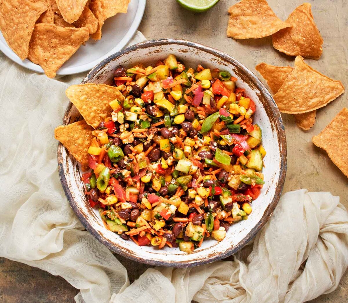 Overhead view of the Eat Your Veggies Salad in a bowl with tortilla chips on the side.