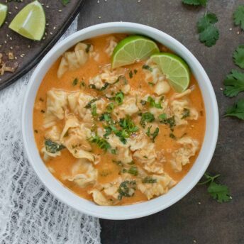 Overhead view of a bowl of Thai Red Curry Dumpling Soup in a white bowl.