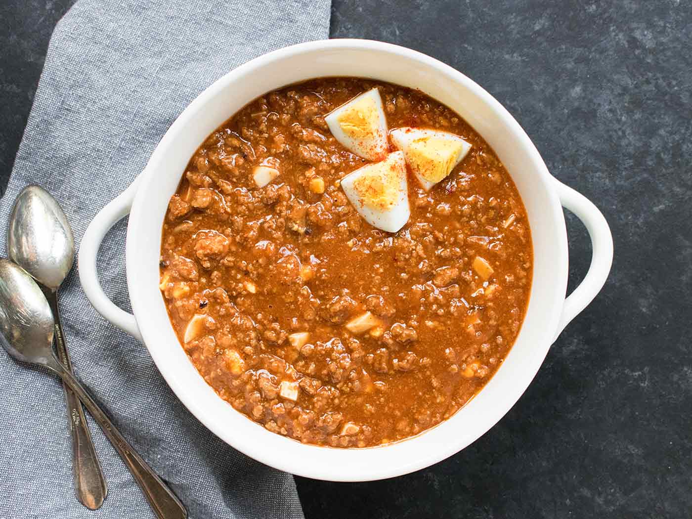 Mock Turtle Soup in a white bowl topped with sliced hard boiled eggs.