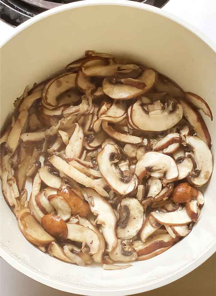 Sliced mushrooms cooking in the soup pot.