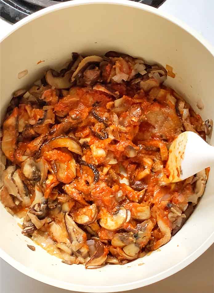 Mixing the seasonings into the mushrooms.