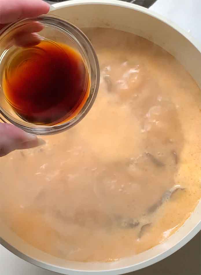Adding the fish sauce to the bubbling soup.