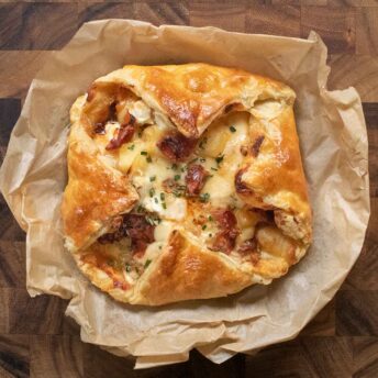 Overhead view of Baked Cheesy Puff Pastry with Crispy Prosciutto on parchment paper.