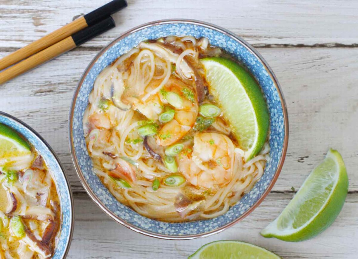 Overhead view of a bowl of Thai Curry Shrimp Soup with chopsticks on the side.