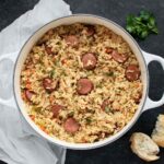 An overhead view of Chicken Bog in a large white Dutch oven.