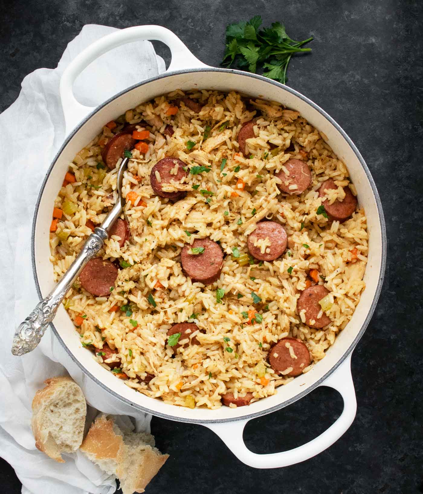 Overhead view of chicken bog in a large pot with a serving spoon.