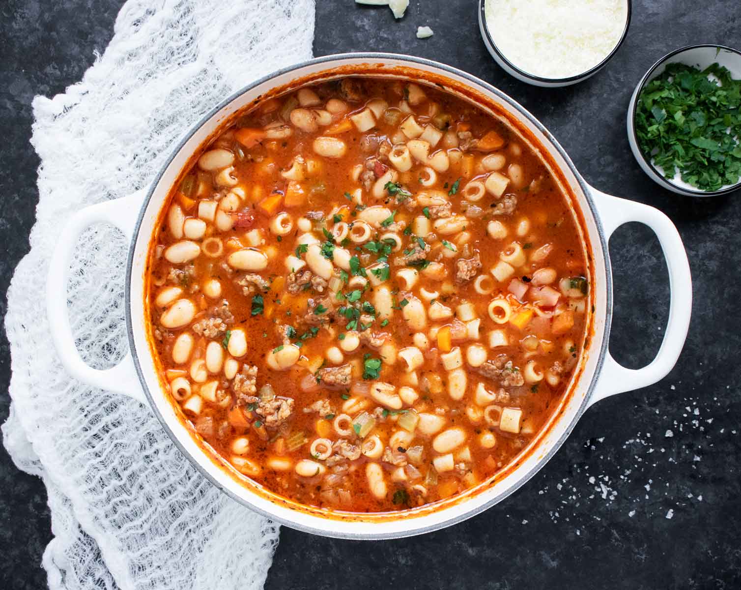 Overhead view of Pasta e Fagioli in a large white Dutch oven.