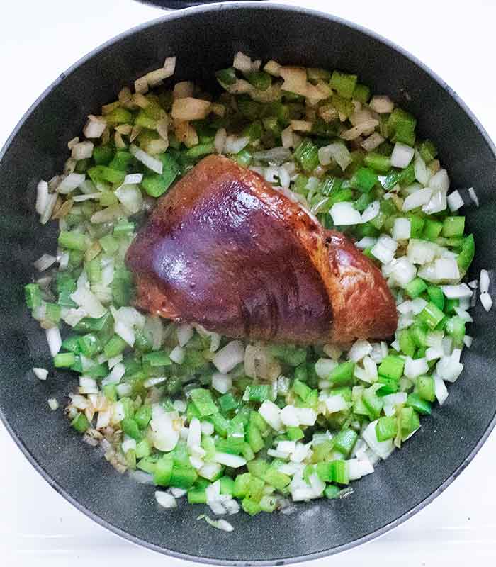 Positioning the ham hock in the pot.