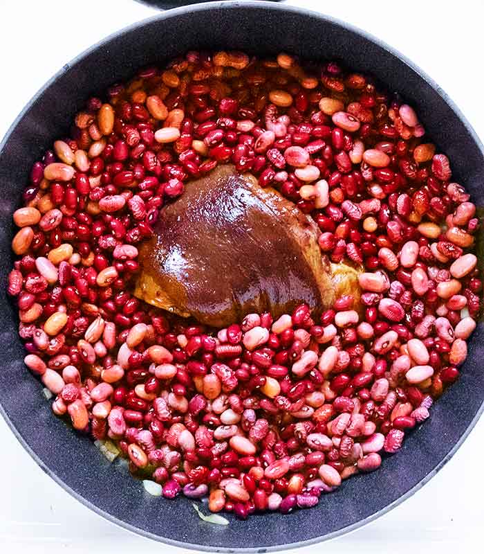 Adding the soaked and drained beans to the pot.