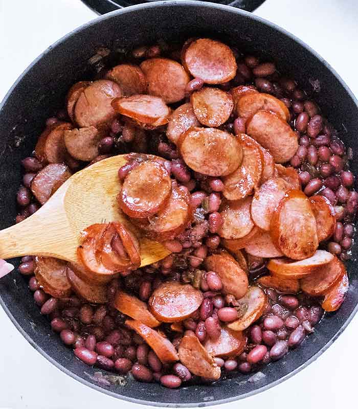 Stirring in the browned andouille sausage.