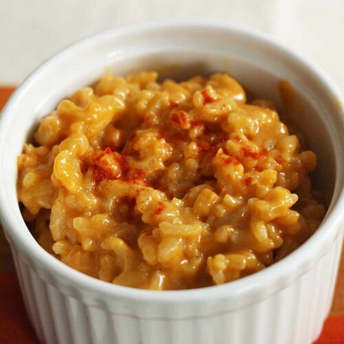 Side-angled view of Cheddar Risotto in a large white ramekin.