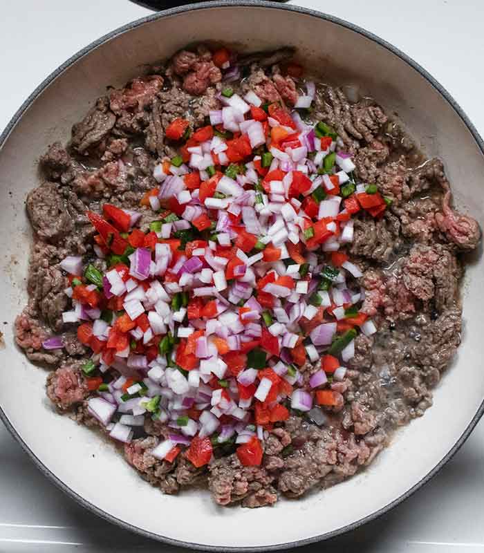 Adding the aromatic vegetables to the pan