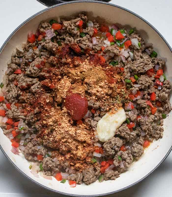 Adding the seasonings to the beef mixture.