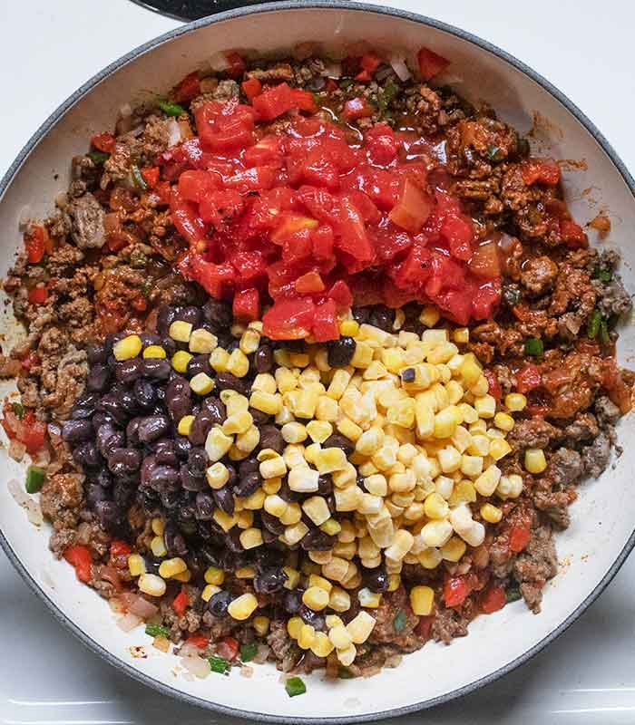 Add the tomatoes, beans, and corn to the pan.