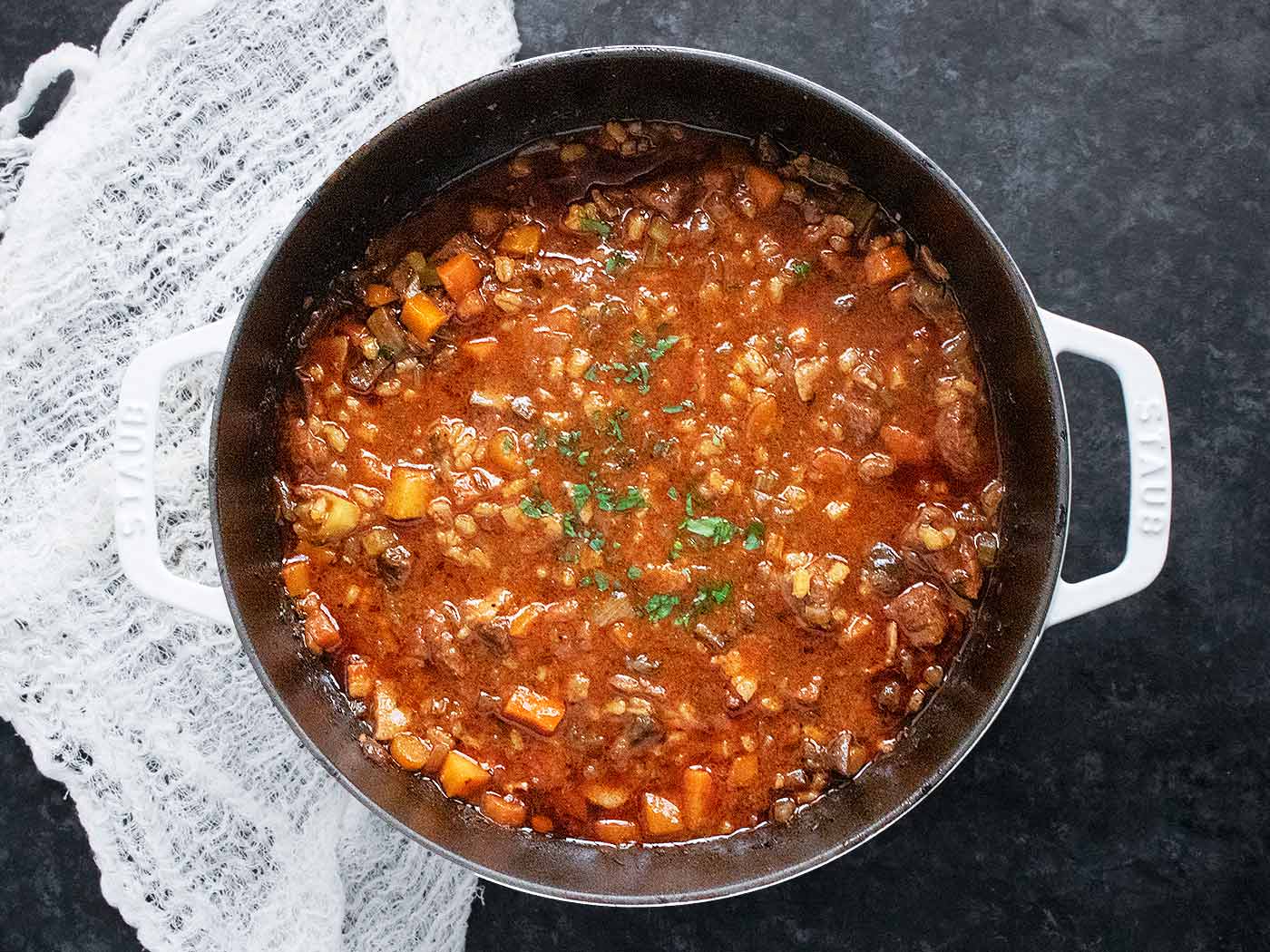 An overhead view of Beef Barley Soup in a large Dutch oven.