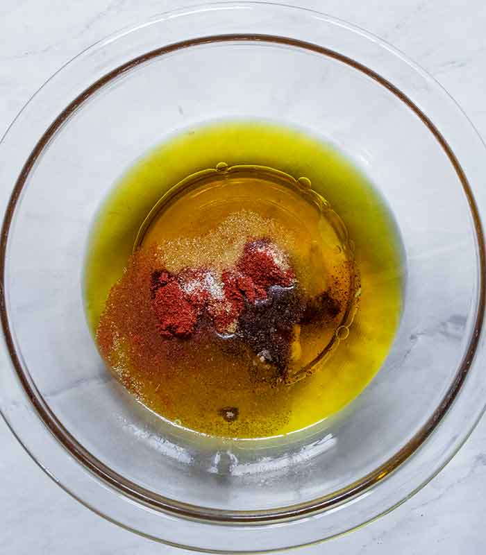 The ingredients for the vinaigrette in a small glass bowl.
