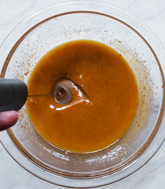 Blending the vinaigrette ingredients using a milk frother.
