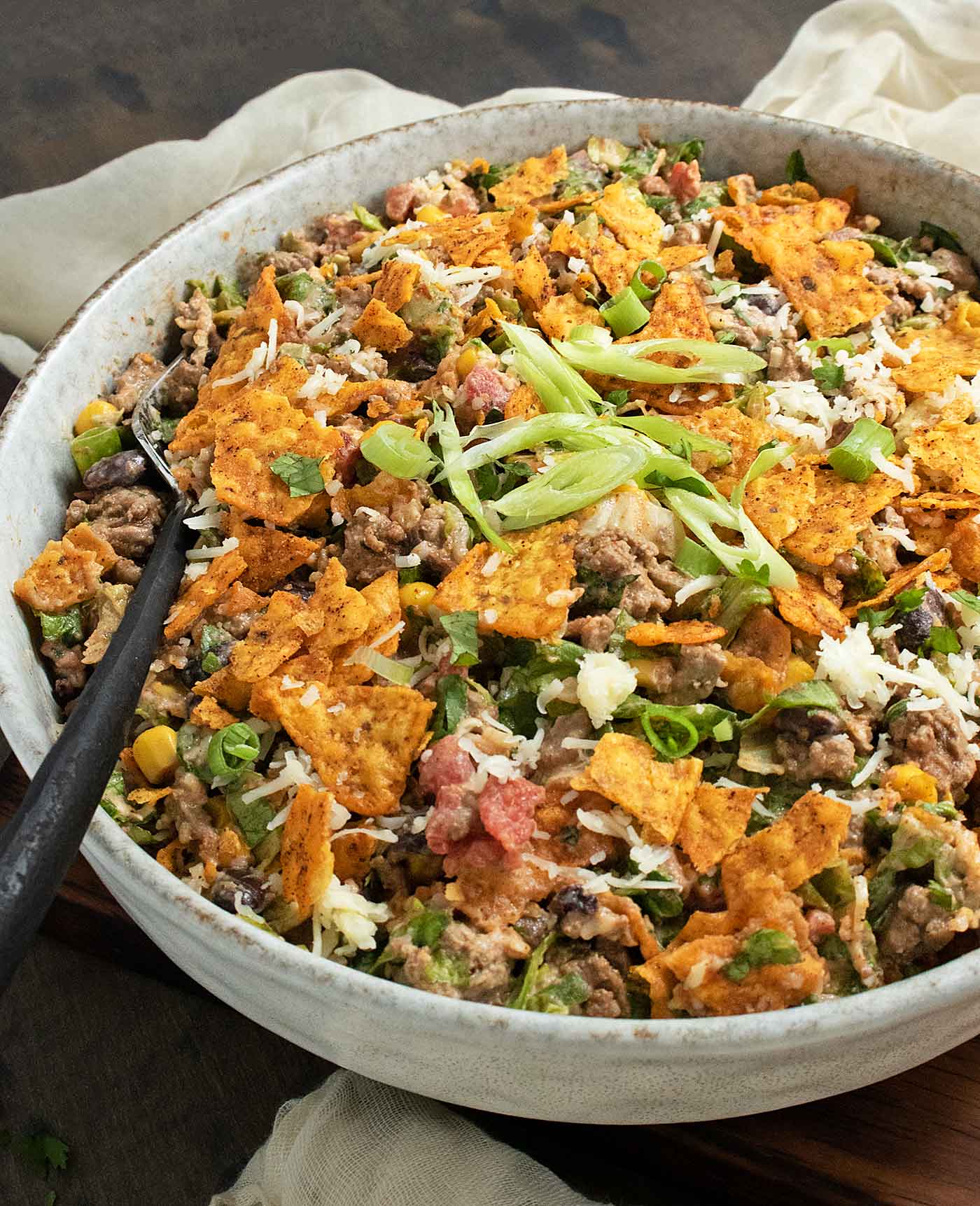 Side-angled view of Doritos Taco Salad in a large bowl with a fork.